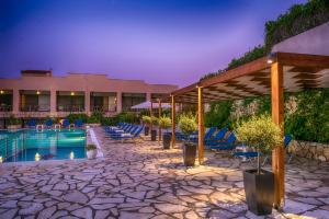 ein Resort mit Pool und Liegestühlen und einem Gebäude in der Unterkunft Ipsos Holidays in Ýpsos
