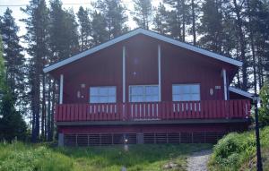 a red house with a red deck in the woods at Holiday Home Hemnes Vestre Sundby in Vortungen