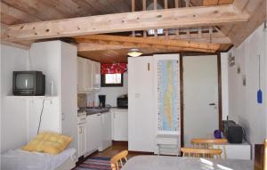 LöttorpにあるNice Home In Lttorp With 3 Bedrooms And Wifiの白いキャビネット付きのキッチン、ベッド1台が備わる客室です。