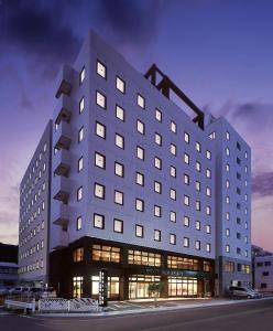 ein großes weißes Gebäude mit vielen Fenstern in der Unterkunft Hotel New Amami in Amami