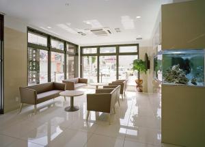 a lobby with couches and tables and a fish tank at Hotel New Amami in Amami