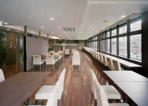 a dining room with white tables and white chairs at Hotel New Amami in Amami