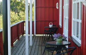 a red house with two chairs and a table on a porch at Holiday Home Hemnes Vestre Sundby in Vortungen