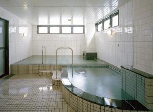 ein Badezimmer mit einem Wasserbecken im Badezimmer in der Unterkunft Hotel New Amami in Amami