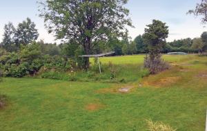 a field with a tree in the middle of it at Gorgeous Home In Vårgårda With Wifi in Vårgårda