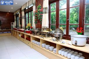 a kitchen with several dishes on shelves and windows at Lam Nghiep Do Son Hotel in Ðố Sơn