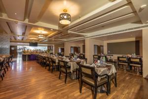 a dining room with long tables and chairs at Best Western Ramachandra in Visakhapatnam