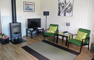 a living room with two chairs and a fireplace at 3 Bedroom Cozy Home In Hemnes in Vortungen