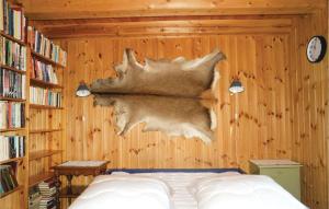 1 dormitorio con 1 cama y pared de madera en 3 Bedroom Amazing Home In Sjusjen, en Sjusjøen