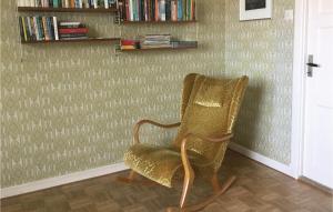 uma cadeira sentada num quarto com uma parede em Awesome Home In Slvesborg With Wifi em Sölvesborg