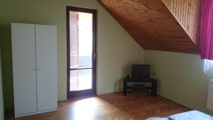 1 dormitorio con cama, ventana y TV en Zala Vendégház en Zalacsány