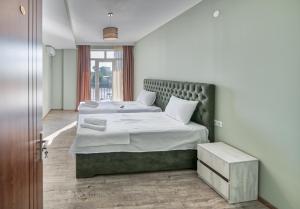 a bedroom with two beds with white sheets at Four Seasons Riverside in Kutaisi