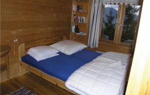 a bed with two pillows in a wooden room at 3 Bedroom Amazing Home In Balestrand in Balestrand