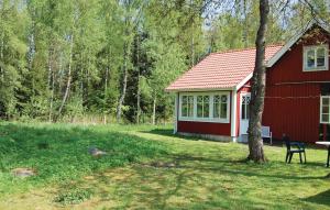 a red barn with a table and a chair in front of it at Holiday Home Knihult Häradsbäck in Knihult