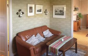 a living room with a brown leather couch and a table at Awesome Home In Sölvesborg With Wifi in Sölvesborg +9 photos