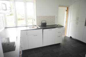 a kitchen with white cabinets and a sink at Sædding Strandvej (ID 119) in Esbjerg