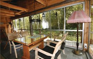 uma sala de jantar com mesa e cadeiras e uma grande janela em Nice Home In Mellerud With Sauna em Torp