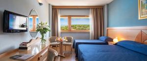 una camera con letto blu e specchio di Grand Hotel Continental a Tirrenia
