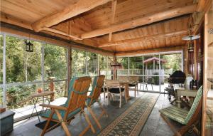 un porche cubierto con mesa y sillas en Nice Home In Mellerud With Sauna en Torp