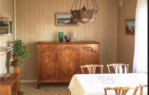a dining room with a table and a wooden cabinet at Awesome Home In Sölvesborg With Wifi in Sölvesborg