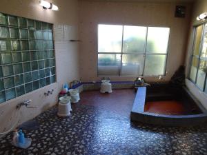 a large bathroom with a tub and two toilets at Asumi Onsen in Fujiyoshida