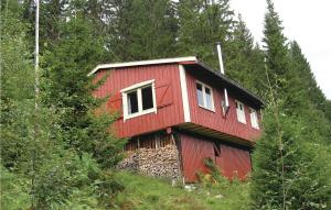 巴里斯川的住宿－3 Bedroom Amazing Home In Balestrand，一座红房子,位于一座树木繁茂的山顶上