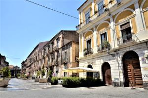 ein Gebäude mit einem Regenschirm auf einer Stadtstraße in der Unterkunft B&B al Teatro Massimo in Catania