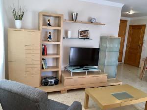 Televízia a/alebo spoločenská miestnosť v ubytovaní APARTAMENTO CON TERRAZA, VISTAS AL MAR Y PISCINA