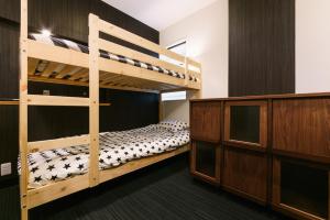 a bedroom with two bunk beds and a cabinet at Guest House Yasuragi Hakataekimae in Fukuoka