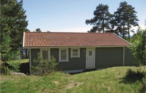uma pequena casa cinzenta com um telhado vermelho em Nice Home In Rygge With 3 Bedrooms And Internet em Saltnes