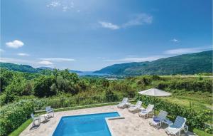 an outdoor swimming pool with chairs and an umbrella at Cozy Home In Igalo With Wifi in Herceg-Novi