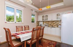 a kitchen with a table and chairs and a refrigerator at Cozy Home In Igalo With Wifi in Herceg-Novi