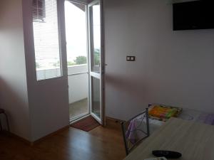 an empty room with a window and a table and a room with a television at Guest House Emi in Balchik