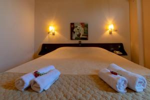 a bedroom with a bed with towels on it at Aegli Hotel in Perama