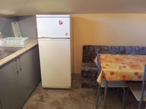 a small kitchen with a refrigerator and a table at Guest House Emi in Balchik