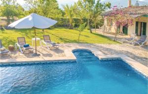 una piscina con 2 sillas y una sombrilla en Gorgeous Home In Selva With Outdoor Swimming Pool, en Selva