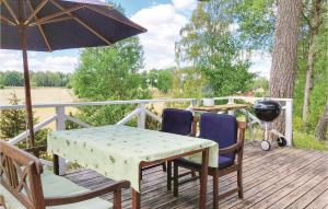 a table and chairs on a deck with an umbrella at Three-Bedroom Holiday Home In Bodafors in Bodafors +17 photos