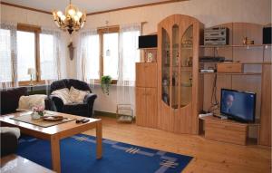 a living room with a couch and a table and a tv at Cozy Home In Ankarsrum With Lake View in Ankarsrum