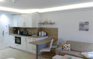 a kitchen with white cabinets and a table and a couch at Angel in Binz