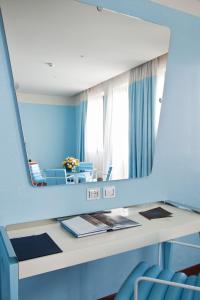 a dressing table with a mirror on a blue wall at JR Hotels Bari Grande Albergo delle Nazioni in Bari