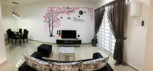 a living room with a couch and a tv at De Little Cabin - 7mins to Sunway Iost World of Tambun in Ipoh