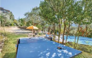ein blauer Tisch mit einem Sonnenschirm neben einem Pool in der Unterkunft Casale Petrucci in Vacone