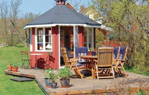 a gazebo with chairs and a table on a deck at Awesome Home In Slvesborg With Kitchen in Hällevik