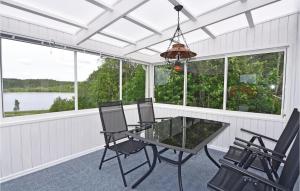 a screened in porch with a glass table and chairs at Holiday Home Hedekas 08 in Hedekas