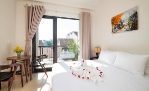 um quarto com uma cama branca e uma varanda em Backhome Hostel & Bar em Hoi An