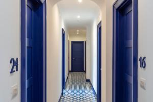 a hallway with blue doors and a tile floor at Hotel Mignon Meublè in Sorrento
