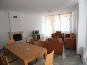 een woonkamer met een tafel en stoelen en een bank bij Monastery 3 Apartments TMF in Pamporovo