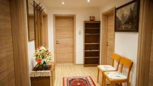 ein Zimmer mit 2 Stühlen und einem Tisch mit Blumen darauf in der Unterkunft Apartment Ginzling in Mayrhofen