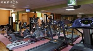 a gym with rows of treadmills and exercise bikes at Sissy Village All Suite Hotel in Kounoupidhianá