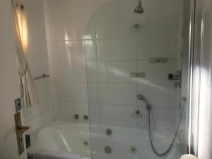La salle de bains blanche est pourvue d'une douche et d'une baignoire. dans l'établissement Sleepers Villa Guesthouse, à Polokwane